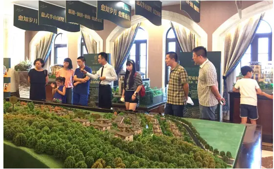 置业顾问为看房团朋友介绍项目情况